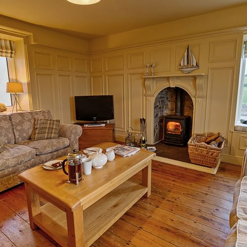 Cable Cottage Church Bay Anglesey living room tea by the fire 1920x1080