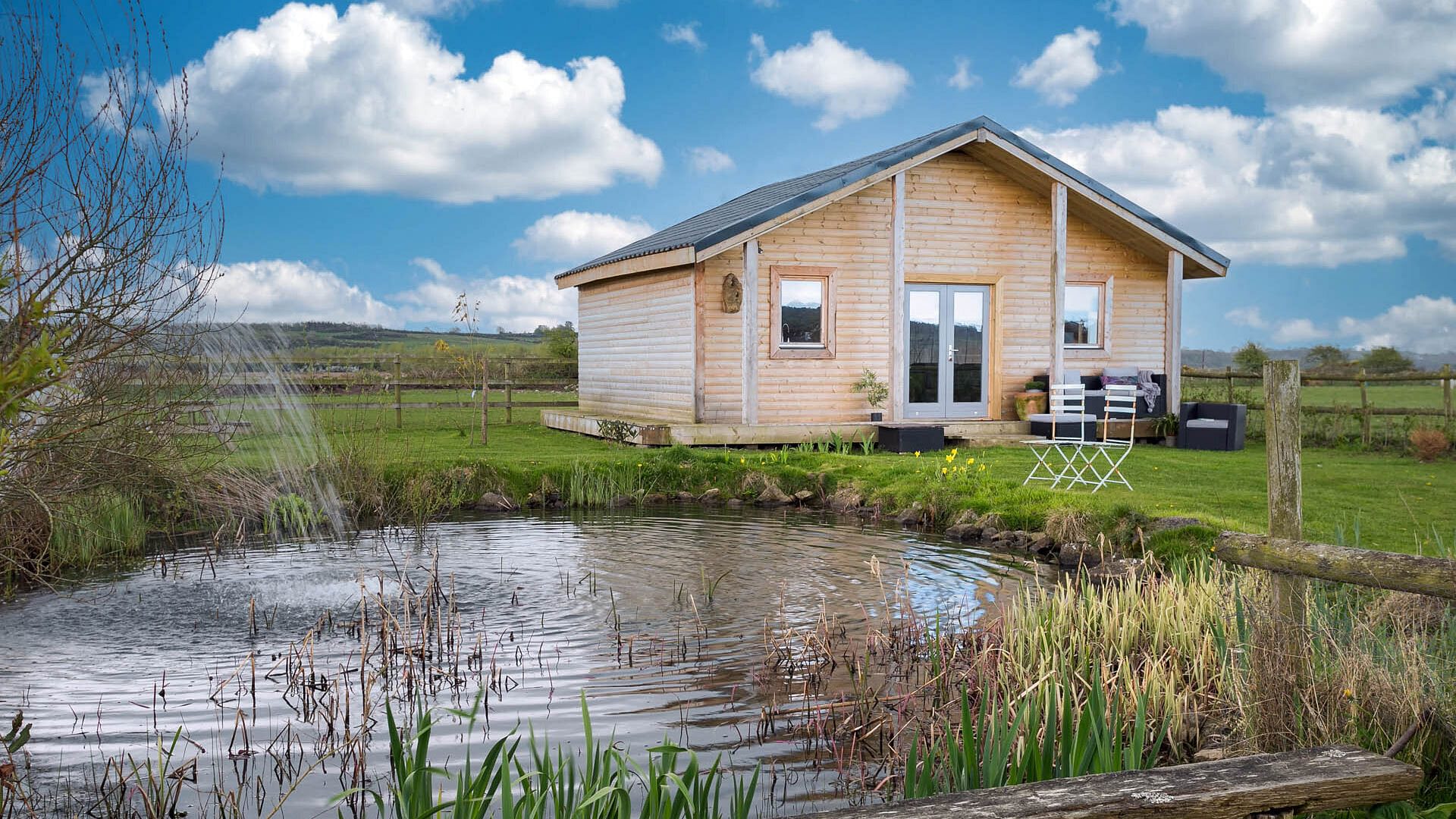 Peacock Cabin Bodorgan Anglesey exterior view pond 3 1920x1080